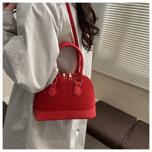 Side view of red leopard print shell bag worn by model in a minimalist setting