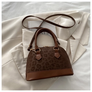 Detailed close-up of vintage shell bag with leopard print and golden hardware accents