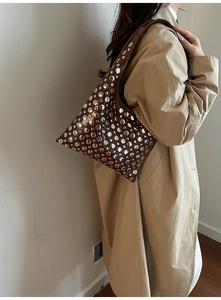 Close-up of gothic punk brown leather shoulder bag with silver rivet studs on a model