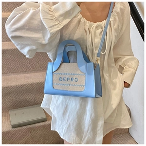 Détail du sac bandoulière bleu clair avec broderie BEPRO et fine bandoulière réglable