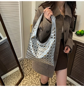 Détail du sac hobo croissant argenté avec rivets métalliques et texture lisse élégante