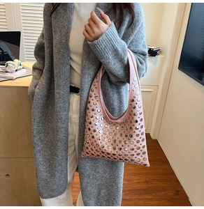 Détails des rivets métalliques argentés sur le sac hobo rose en similicuir lisse