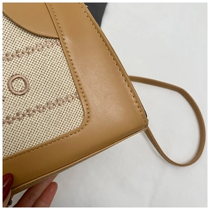 Detail shot of khaki leather and beige canvas stitching with fine embroidery and stitching