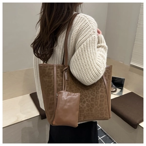 Dettaglio della borsa tote leopardata con pochette coordinata e manici in pelle scura