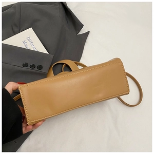 Close-up of the rectangular base and high-quality stitching on a brown leather shoulder bag