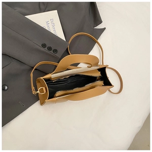 Top view of interior compartment with black lining and metal zipper of tan square bag