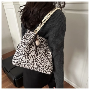 Detalle de bolso de hombro con estampado de leopardo, asa tejida y colgante de helado