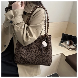 Dettaglio della borsa tote leopardata con manici intrecciati e ciondolo a gelato