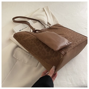 Detail of leopard print tote bag texture with matching mini zipper pouch accessory