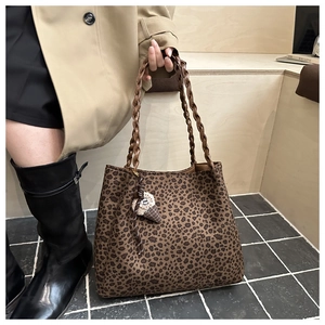 Dettaglio della borsa tote leopardata con tracolle intrecciate e ciondolo a gelato