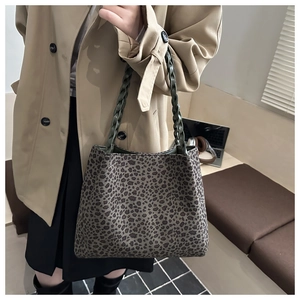 Dettaglio della borsa tote leopardata con manico intrecciato verde e trama in tela elegante