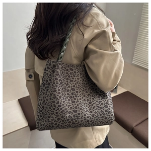 Dettaglio della borsa tote leopardata con manici intrecciati in resina verde