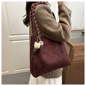 Dettaglio della borsa tote leopardata con manici intrecciati e ciondolo di peluche a gelato
