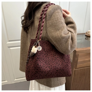 Detail of burgundy leopard print tote bag with woven handle and plush ice cream charm