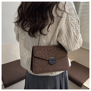 Détail du sac bandoulière mat léopard rétro avec boucle métallique noire et chaîne