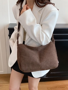 Retro minimalist large capacity dark coffee shoulder bag with adjustable strap worn by model