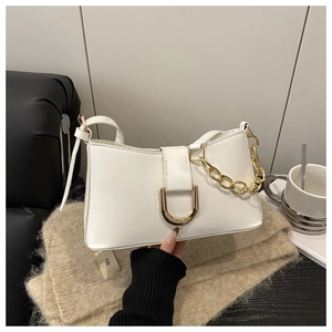 Gros plan d'un sac baguette en cuir blanc avec boucle en U dorée et bandoulière chaîne épaisse