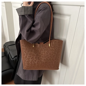 Detail shot of a large leopard print tote bag with brown faux suede texture and gold hardware