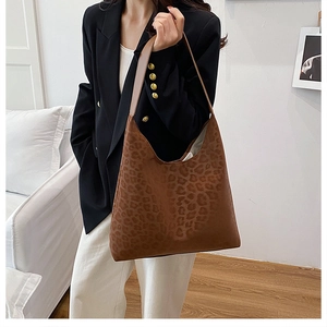Detailed view of leopard print tote bag with soft suede texture and brown strap