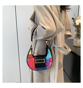 Detail shot of multicolor geometric faux leather shoulder bag with a gold metal buckle