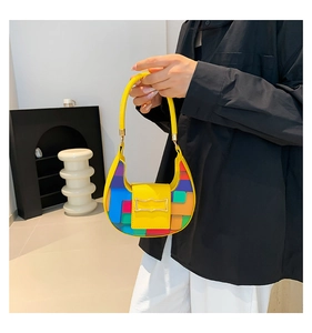 Detail of yellow crescent bag with colorful geometric side panels and gold buckle
