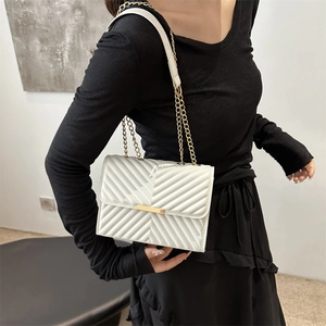 Minimalist white quilted shoulder bag with gold chain strap and elegant metal lock