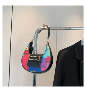 Detail of multi-color geometric patchwork hobo bag with black leather flap and gold buckle