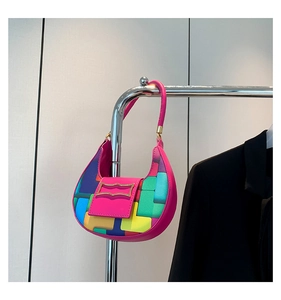 Close-up of crescent underarm bag featuring colorful geometric patches and gold buckle