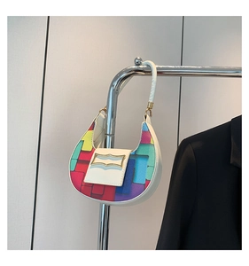 Detail view of colorful geometric patchwork pattern on a mini crescent shoulder bag