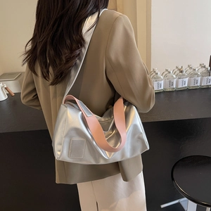 Sac fourre-tout argenté métallisé avec large bandoulière rose porté par un mannequin