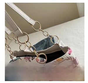 Detail view of colorful butterfly tote bag with golden metal rings and chain link handle