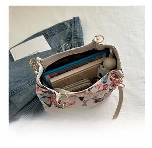 Detail view of white butterfly print tote bag showing spacious interior with tablet and books