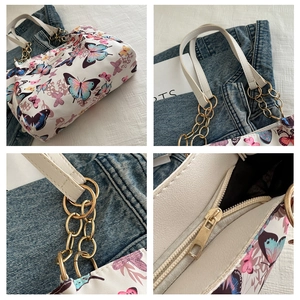 Close-up of butterfly print tote with golden metal chain straps and zip closure details