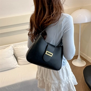 Sac sous le bras chic en cuir noir en forme de croissant avec boucle dorée sur modèle