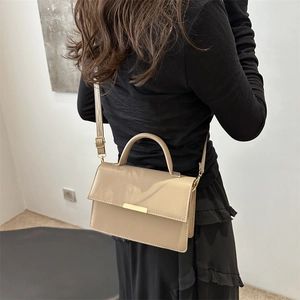 Minimalistische kaki rechthoekige crossbodytas met gouden details op een model