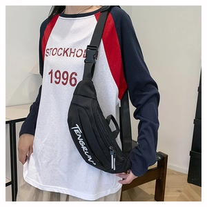 Close-up of black nylon chest bag with white text print and adjustable shoulder strap
