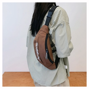 Detail of adjustable black nylon strap and plastic buckle on brown canvas fanny pack