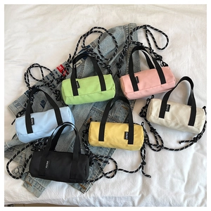 Mini sacs cylindriques en six couleurs avec bandoulières tissées sur fond blanc élégant
