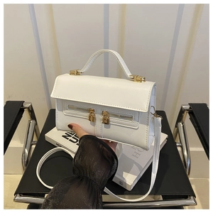 Close-up of white crossbody bag with gold padlock detail and double zippers on black chair