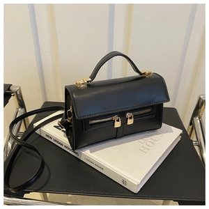 Detailed macro view of black matte leather bag with golden lock and dual zipper front pockets