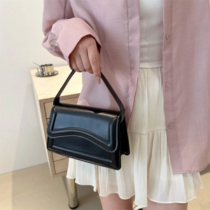 Fashionable black leather underarm bag with unique wavy edge design for daily wear