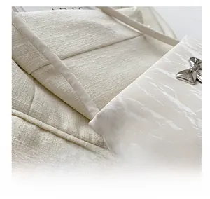 Detailed view of white pleated leather bag featuring a silver mirror bow buckle
