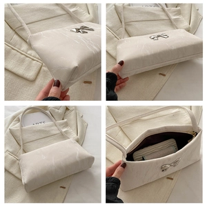 Detailed views of white marble textured handbag featuring a silver metal bow clasp