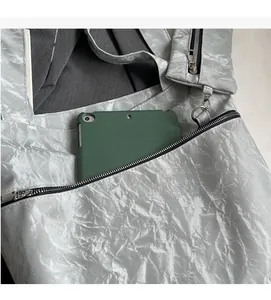 Detail of silver metallic pleated tote showing spacious capacity and front zipper pocket