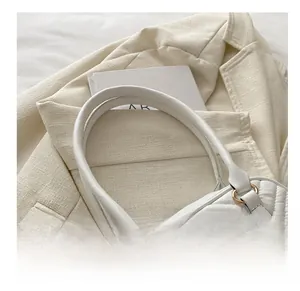 Detail showing white quilted leather texture and vintage relief badge on the handle
