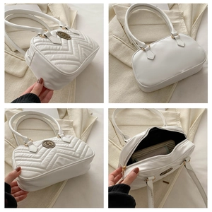 Detailed views of white quilted PU leather Boston bag with V-shaped stitching and bronze logo