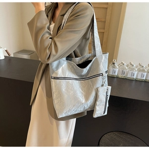 Detail of silver pleated tote bag featuring a zipped front pocket and matching coin purse