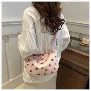 Detail of pink corduroy dumplings bag with strawberry pattern on model back