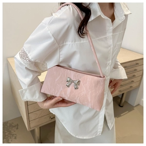 Détail du sac à bandoulière en cuir plissé rose clair avec un nœud métallique argenté