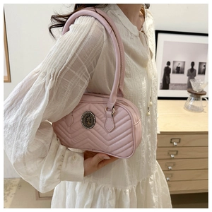 Detail of light pink quilted handbag featuring V-shape stitching and vintage logo